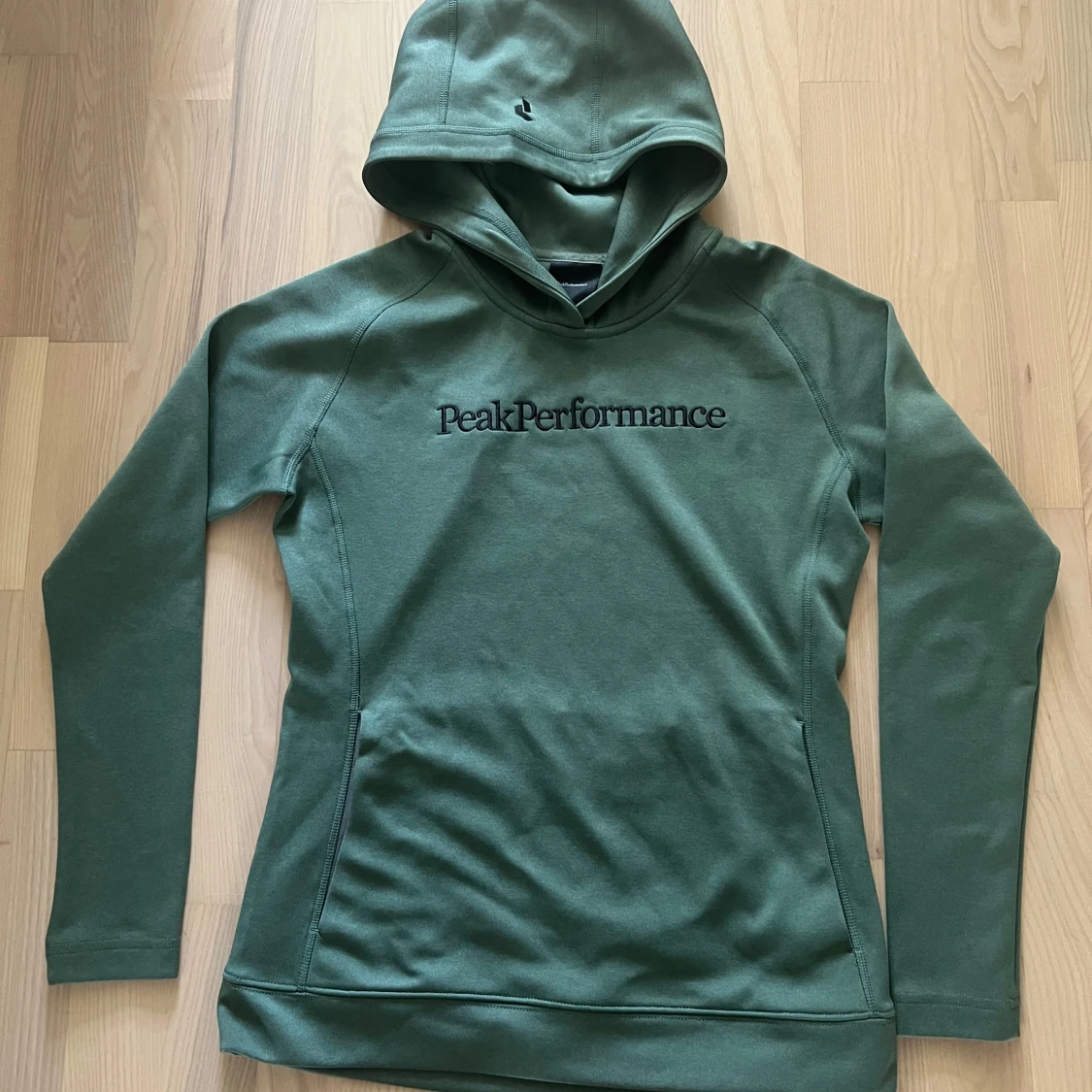 Grön hoodie från Peak Performance