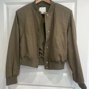 Kamouflage grön bomberjacka från H&M - Säljer en snygg kamouflage grön bomberjacka från H&M i linneblandning. Jackan är i nyskick, säljer då den inte används! Perfekt nu till våren💕 kontakta om ni har fler frågor 