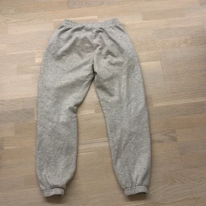 Grå mjukisbyxor från Gina Tricot - Säljer ett par bekväma grå mjukisbyxor från Gina Tricot. Byxorna har elastisk midja och muddar vid bensluten för en skön passform. Perfekta för en avslappnad dag hemma eller en snabb tur till affären. Priset går att diskuteras. 