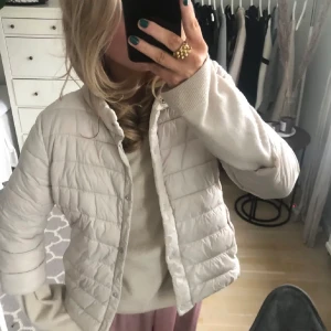 Trekvartsärmad jacka från Amisu - Säljer en snygg beige quiltad jacka från Amisu. Jackan har en lätt och bekväm passform med korta ärmar och knäppning framtill. Perfekt för kyligare dagar och enkel att matcha med olika outfits. Även lite rosa nyans!!