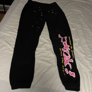 Svarta mjukisbyxor med tryck - Svarta mjukisbyxor från Sp5der med färgglatt tryck på ena benet. Byxorna har en avslappnad passform och är perfekta för en chill dag. De har elastisk midja för extra komfort.