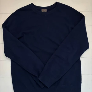 Mörkblå kashmirtröja från Singular Society - Säljer en elegant mörkblå kashmirtröja från Singular Society. Tröjan har en klassisk design med långa ärmar och rund halsringning. Perfekt för en stilren och bekväm look. 🧥