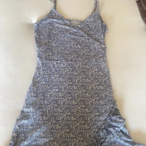 Klänning från Gina tricot - Söt blommig omlottklänning med smala axelband. Perfekt för varma dagar med sitt lätta och luftiga material. Klänningen har en fin omlottdetalj framtill och en subtil volang vid fållen.Kan diskutera priset vid snabb affär 