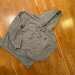 Grå hoodie från Polo Ralph Lauren - Säljer en stilren grå hoodie från Polo Ralph Lauren. Den är nyskick då den bara används fåtal gånger. Inga defekter. Tröjan har en bekväm passform med långa ärmar och justerbar huva. Modellen är 183 cm. Nypris runt 1999kr | Mitt pris 799kr! Skriv vid minsta fundering