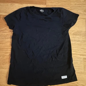 Svart t-shirt från 157 - Säljer en klassisk svart t-shirt från 157. Den har en rund halsringning och korta ärmar, perfekt för vardagsbruk. T-shirten är tillverkad i ett mjukt och bekvämt material.