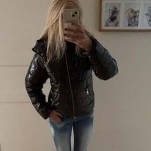 Svart glansig jacka - Säljer en svart glansig pufferjacka från Nelly. Orginalpris 800, säljer för ska byta jacka tills nästa vinter annars så fin💕