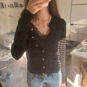 Svart kofta med spetsdetalj och knappar - Säljer en svart kofta med snygga guldknappar. Koftan är långärmad och har en feminin passform som passar perfekt till jeans eller kjol💕Perfekt att ta på sig på en sommarkväll när det börjar bli lite kyligt