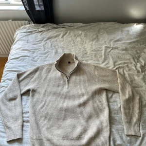 Beige stickad half zip-tröja Uniqlo - Passar M/L! Ribbstickad beige tröja från Uniqlo i storlek S. Tröjan har en hög krage med half zip-dragkedja och långa ärmar. Perfekt för lager-på-lager och chill höst- eller vinterstil. Materialet är mjukt och värmande, passar dig som gillar enkel och clean look. 