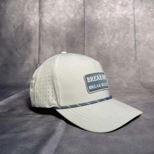 BREAK 80 - Vår första model med textpatchen ”BREAK 80? BREAK RULES!”. Kepsen har perforerade sidor för extra ventilation och ett grått kantsnöre längs skärmen. Köp och ha den på din nästa golfrunda!