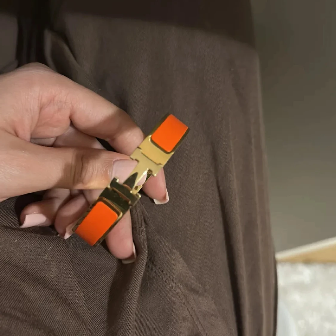 Guldarmband med orange detaljer