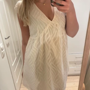 Ljus kortklänning med volangärmar - Supersöt ljus kortklänning med v-ringning och volangärmar. Vet ej vad märket är då lappen är borta💓💓