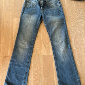 Blå bootcut jeans - Snygga blå jeans med bootcut passform och klassiska fem fickor. Lappen bortklippt men skulle att passar storlek S-M. Inga skador förutom få vita fläckar på högra benet baksida. 