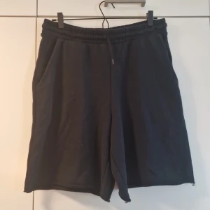 Svarta loose shorts med snörning - Svarta shorts med loose fit och elastisk midja med snörning. Mjukt material och två sidofickor, perfekt för chill dagar eller träning. Klassisk och enkel design utan mönster eller logga.