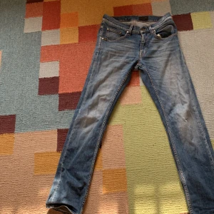 Tiger of Sweden jeans - Säljer ett par blå jeans med klassisk tvätt och raka ben. Jeansen har fem fickor, normal passform och är tillverkade i slitstarkt denim. Perfekta för en avslappnad och stilren look.
