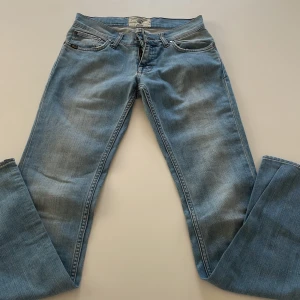 Ljusblå bootcut jeans från tiger of Sweden  - Säljer ett par ljusblå jeans från tiger of sweden med klassiska kontrastsömmar och femficksmodell. Jeansen har bootcut-ben och låg midja, tillverkade i mjukt denim med snygg tvätt. Perfekta för dig som gillar en trendig look.