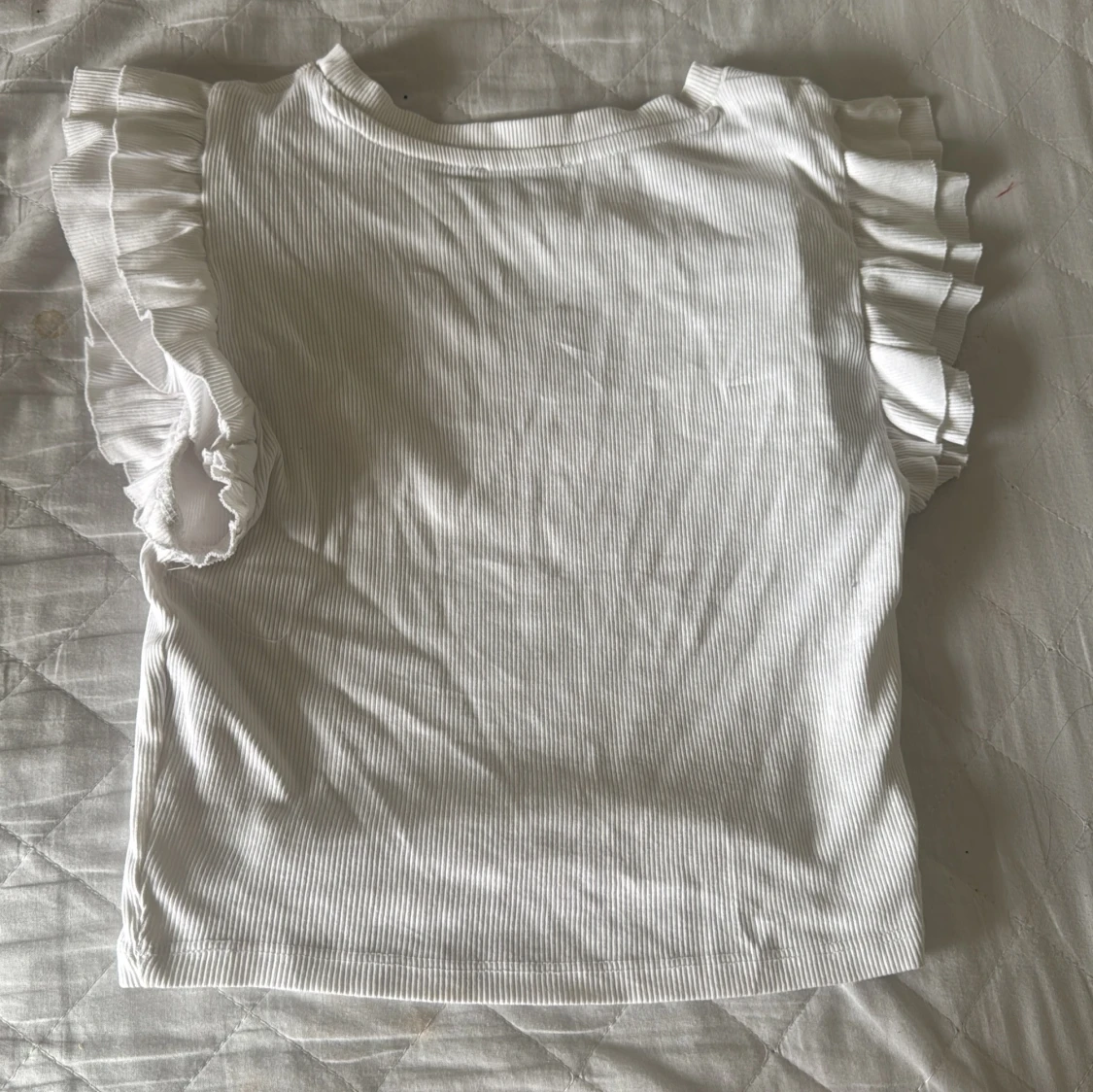 Vit ribbad topp med volangärmar