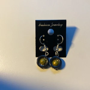 Handgjorda, Eleganta Runda örhängen med guldfärgad kula *Endast 1 Kvar* - Coola örhängen med rund form och en glansig guldfärgad kula i mitten. Metallfärgad ram och krok i silverfärg. Snyggt futuristisk vibe och passar perfekt om du vill sticka ut lite extra.