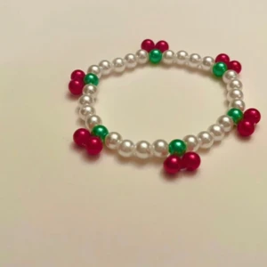 Cherry bracelet pärlat armband med körsbär 🍒 - Supergulligt armband som är pärlat med körsbärsmönster! Elastiskt.  Armbandet är ca 17 cm långt, vill du ha större eller mindre så skicka ett meddelande så löser jag det :)