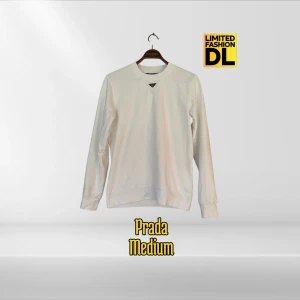 Prada Sweatshirt / Logo Crewneck  - Vit sweatshirt från Prada med avslappnad passform, rund hals, ribbade muddar och den ikoniska metalltriangeln framtill. Tröjan är 100% bomull. Perfekt för vardagslooken men även till mer formella tillfällen. 