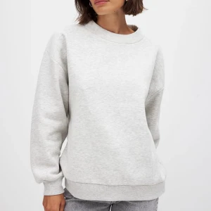Ljusgrå oversized sweatshirt - Enkel och stilren ljusgrå sweatshirt med rund hals och avslappnad oversized passform, jag har använt den typ 2 gånger. Så den är i nyskick!  Tröjan har långa ärmar och breda muddar. Länk till plagget där jag köpte det om du vill kika på fler detaljer: https://www.na-kd.com/sv/produkter/high-neck-detail-sweatshirt-grey-melange-1100-010094-0138