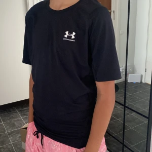Svart Under Armour t-shirt  - Svart t-shirt från Under Armour med HeatGear-teknologi. Klassisk passform med korta ärmar och rund hals. Diskret logga på bröstet och bak i nacken. Perfekt för träning eller sportiga dagar. Materialet är lätt och andas, vilket gör den skön att ha på sig. Han är storlek xs och den är ganska stor så den är typ S/M🤍🤍