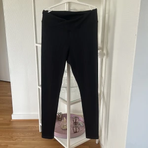 Svarta ribbade leggings från H&M Divided - Svarta ribbade leggings från H&M Divided i storlek M. De har en snygg omlott-detalj i midjan och är tillverkade i stretchigt material som sitter tight och bekvämt. Perfekta till en oversized hoodie eller crop top.