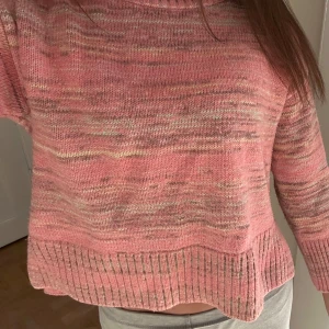 Rosa stickad tröja från GAP Kids - Supermysig rosa stickad tröja från GAP Kids i storlek L. Tröjan har en melerad look med inslag av ljusgult och beige, samt bred ribbad kant nedtill och vid halsen. Perfekt för lager-på-lager och chill dagar.