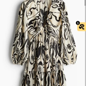 Hm klänning  - Snygg plisserad klänning i svartvitt mönster med djup v-ringning och voluminösa långärmar. Klänningen har ett coolt abstrakt mönster och markerad midja för en trendig siluett. Perfekt för dig som gillar statement-plagg. Slutsåld på hm