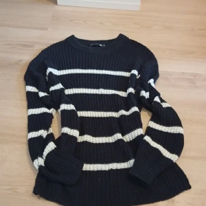 Randig stickad tröja från 157, M - Säljer en svart och vit randig stickad tröja från 157 i storlek M. Tröjan har grovstickad struktur, rund halsringning och långa ärmar. Perfekt för lager-på-lager och chill dagar. Snygg och enkel att matcha med jeans eller kjol.