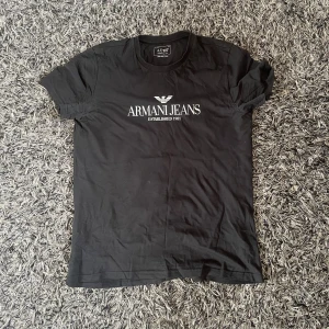 Svart t-shirt från Armani Jeans - Svart t-shirt från Armani Jeans. Tillverkad i 100% prima bomull för en mjuk och skön känsla. Grisch passfrom som ger känslaaa 