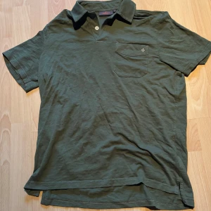 Piké från Morris - Snygg grön pikétröja från Morris och har endast en knapp vid halsen. Köpte den för 899kr och endast använt 3 gånger, lite får stor för mig som är 174 cm och 63 kg