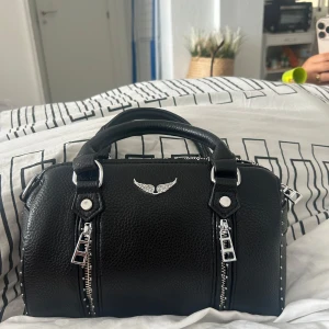 Svart handväska med kedjedetaljer - Jätte fin handväska från Spanien det är helt ny kom precis hem så den är aldrig använd, sålde pågrund av att jag köpte en annan väska, kan gå ner i pris så buda