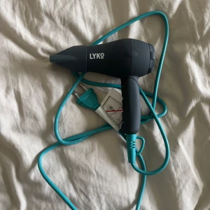 Svart liten hårfön från Lyko med turkos sladd - En kompakt liten svart hårfön från Lyko med en lång turkos sladd. Perfekt storlek för resor eller mindre utrymmen. Enkel att använda och snygg design med tydlig Lyko-logga på sidan. Om du har långt tjockt hår skulle jag inte köpa denna då den är så liten, tar ganska lång tid att få håret torrt då! Så passar någon med kort eller tunt hår! 😍