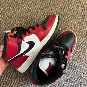 Nike Air Jordan 1 Retro High Chicago - Säljer ett par Jordan 1 Mid “Red” – i mycket fint skick. Skorna är köpta via StockX, som garanterar äkthet, och har endast använts ett fåtal gånger. Inga skador eller större tecken på slitage – fräscha och välbevarade.  Kommer med originalförpackning. Hör av dig vid frågor eller om du vill se fler bilder