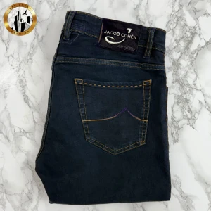 Jacob Cohën (Mått) - Mörkblåa/svarta Jacob Cohën Style 688 Limited Edition jeans i fint skick. Jeansen har inga lagningar eller dolda skavanker förutom att storlekslappen verkar vara avklippt. Det är svårt att avgöra storleken då det skiljer sig en hel del mellan de olika ”generationerna”. Därav se mått. Tveka inte på att höra av dig för fler bilder eller vid minsta fundering! Självklart äkta. Skick: 8,5/10 | Mått A: 46,5cm | Mått B: 106,5cm | Mått C: 83cm 