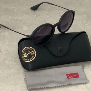 Svarta runda solglasögon från Ray-Ban - Snygga svarta solglasögon från Ray-Ban med rund form och mörka glas. Kommer med originalfodral och putsduk. Allt är helt nytt och helt oanvänt. 