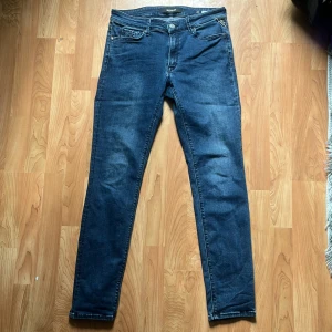 Blå Replay 30/30 - Säljer ett par klassiska blå jeans från Replay i modellen Luzien. Byxorna har fem fickor, dragkedja och knapp framtill samt raka ben. Perfekta för dig som gillar en tidlös och enkel stil. Storlek 30/30 slimfit