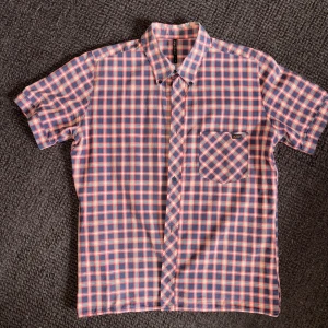 Nudie kortärmad skjorta - Grymt snygg skjorta med kort ärm från Nudie Jeans. Storlek L men sitter mer som en medium. Vissa slitningar efter användning, på kragens baksida -därav det extremt låga priset.