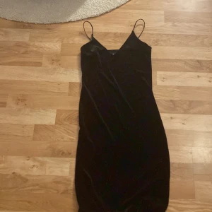 Svart sammetsklänning från Bik Bok - Säljer en svart sammetsklänning från Bik Bok i storlek XS. Klänningen har smala axelband och en figurnära passform med v-ringning. Perfekt för dig som gillar en stilren och elegant look.