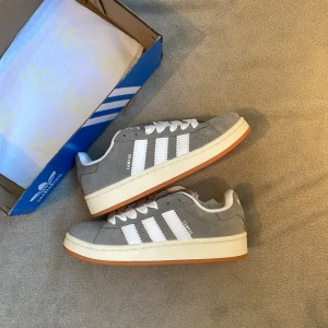 Adidas Campus grå - Adidas campus 00s i grå. Passar storlek 38 En av dem trendigaste skorna till sommaren. Skorna är i ny skick. Nypris 1499 vårt pris 749kr📍  Hör gärna av er vid frågor!