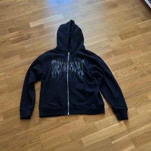 Svart hoodie med tryck från Jack & Jones - Svart hoodie från Jack & Jones med dragkedja och huva. Använd: Lite solblekt men inte mycket! Storlek S men passar mig som är 180cm