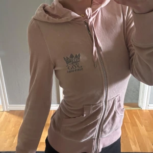 Ljusrosa zip kofta  - Säljer en ljusrosa hoodie i mjuk velour från 365 sunshine med dragkedja och huva. Koftan har fickor framtill och en broderad logga på bröstet. Perfekt för en avslappnad och trendig look.