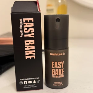 Easy Bake Setting Spray från Huda Beauty - Easy Bake Setting Spray från Huda Beauty i en matt svart sprayflaska, 30 ml. Säljer den för att det är ingenting för mig, flaskan är full 