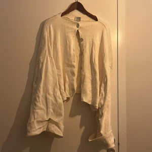 Beige kofta från Arakii - Säljer en beige kofta från Arakii med oversized passform (storlek S) och stora knappar framtill. Koftan har långa ärmar och är stickad i ett mjukt material (100% bomull), perfekt för lager-på-lager-stil. På den sista bilden ser du hur den ser ut på. Nypris är 2300kr 