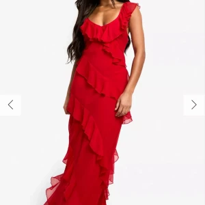 Röd långklänning med volanger - Säljer en röd långklänning med volangdetaljer och v-ringad. Perfekt för bal eller fest. Materialet känns lätt och faller snyggt. Aldrig använd, lappen finns kvar på!