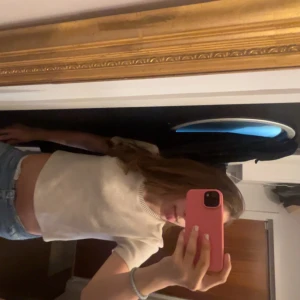 Vit croppad stickad topp - Säljer en vit croppad stickad topp med korta ärmar och rund halsringning. Perfekt för en avslappnad och trendig stil. Passar snyggt till jeans eller kjol.