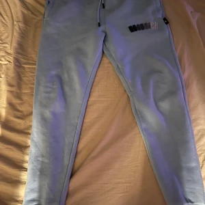 Ljusblå mjukisbyxor från Hoodrich - Säljer ett par ljusblå mjukisbyxor från Hoodrich i storlek S. Perfekta för en avslappnad stil och riktigt sköna att ha på sig. Det ända som är trasigt på byxorna är där vid snöret som man kan se på tredje bilden. Pris kan diskuteras.