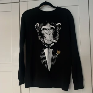 Svart sweatshirt med apa från Originals - Sweatshirt från märket Originals storlek S köpt från kicksnstuff i Göteborg 2022. Har byxor till så om ni vill ha båda så får ni det för 1000kr