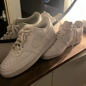 Vita Nike sneakers  - Säljer ett par klassiska helvita Nike sneakers med snörning. Perfekta för dig som gillar stilrena och tidlösa sneakers.