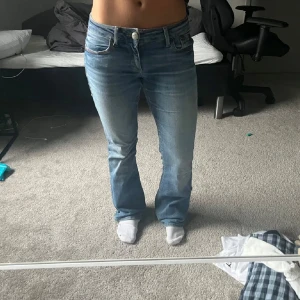 ljusblå bootcut jeans - Säljer ett par  jeans i ljusblå tvätt med klassisk bootcut-passform. Jeansen har fem fickor, normal midja och är tillverkade i mjukt denim. Snygg slitning och råa kanter nertill för en avslappnad vibe.